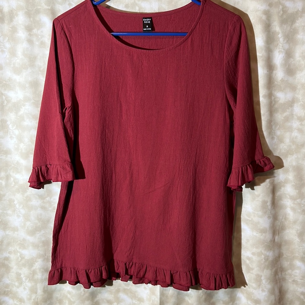 Scoop neck , with Red accented ruffles on the sleeves and bottom.